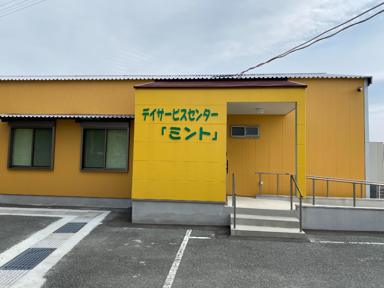 平屋建ての黄色い施設の外観の画像。